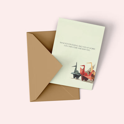Greeting card with origami cranes and a brown envelope on a white background