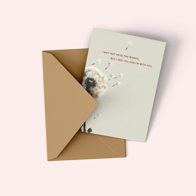 Card with dandelion design and message inside a brown envelope on a light background